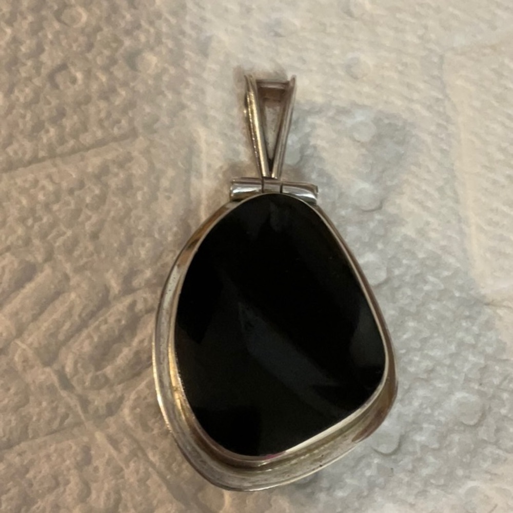 A beautiful onyx silver pendant with reversible side of abalone shell. Excellent